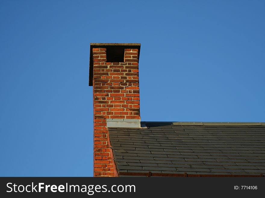 Chimney at a roof top and a blue sky background