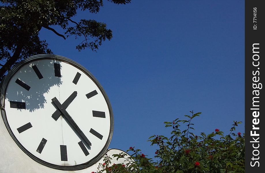 A clock in blue sky background