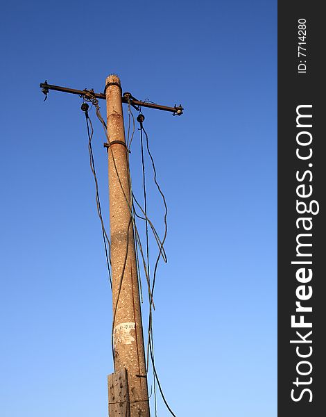 A high voltage power pole against a blue sky. A high voltage power pole against a blue sky