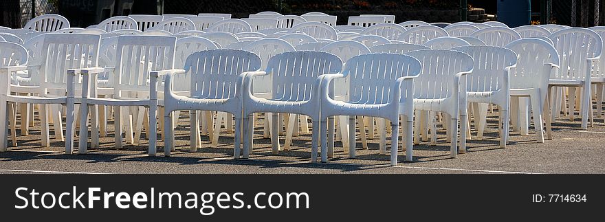 White plastic chairs lined up for a wedding. White plastic chairs lined up for a wedding