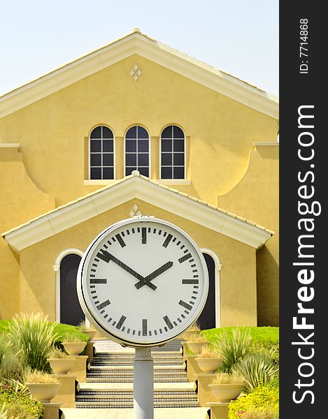 A big clock in front of a very nice house. A big clock in front of a very nice house...