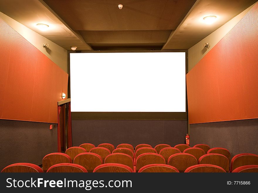 Classical empty cinema auditorium with red chairs