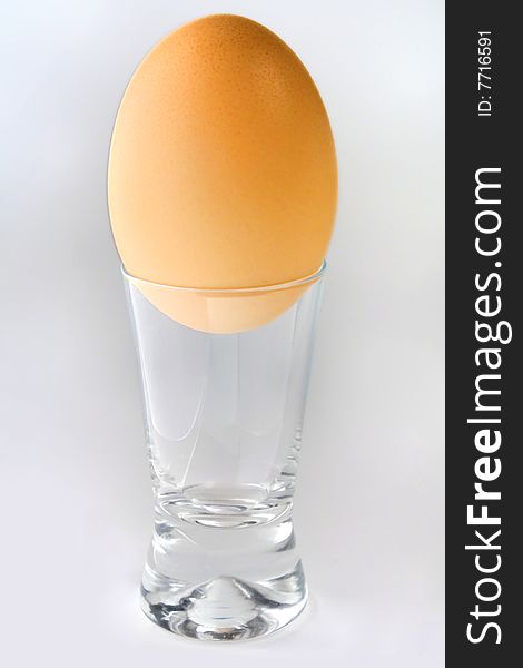 Egg in a wine-glass on a white background
