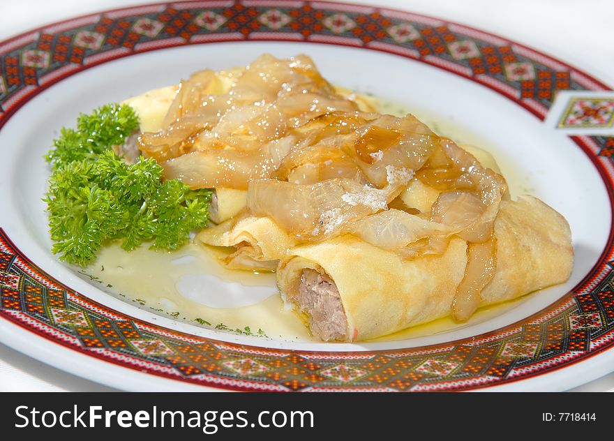 Pancakes with meat on a plate with the Ukrainian ornament