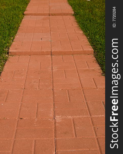 A 3 layered brick path in the middle of a green lawn