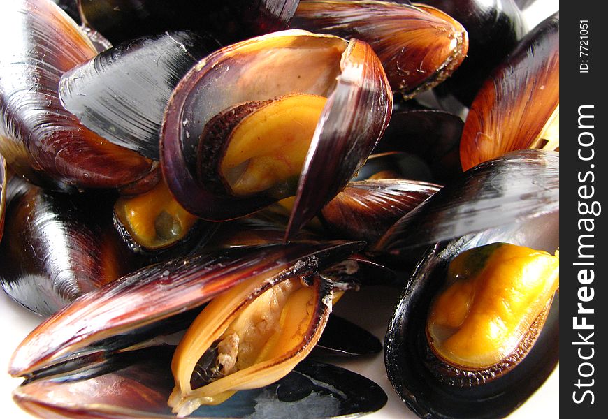 A bowl of steamed muscles on a white background