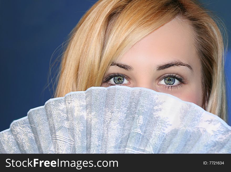 Beautiful blonde with gorgeous eyes holding fan. Beautiful blonde with gorgeous eyes holding fan