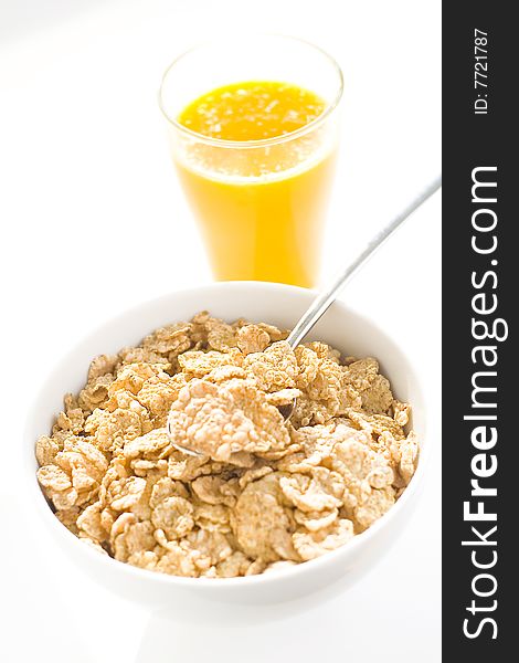 Bowl of cereal with raisins, milk and orange juice