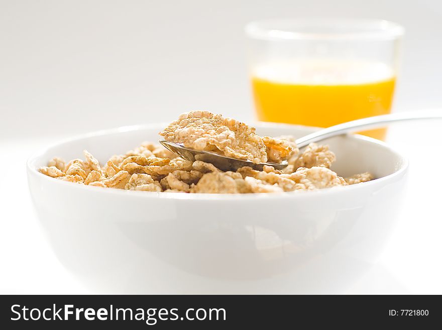 Bowl of cereal with raisins, milk and orange juice