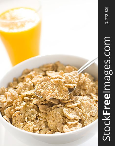 Bowl of cereal with raisins, milk and orange juice