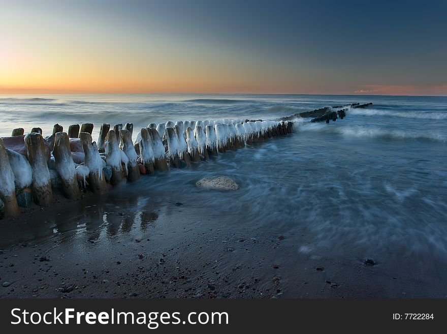 The iced over breakwater on a decline, washed by northern sea