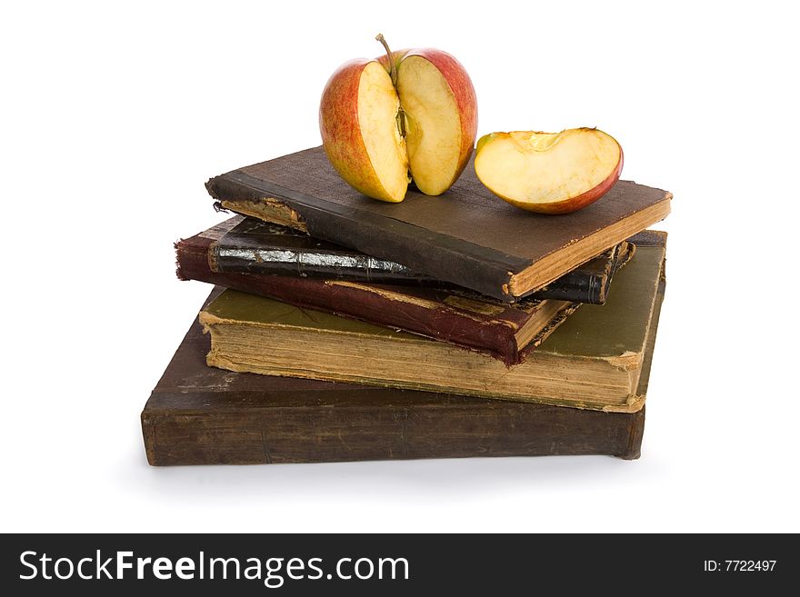 Apple on pile of old books isolated on white