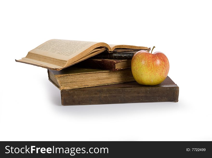 Apple on pile of old books isolated on white