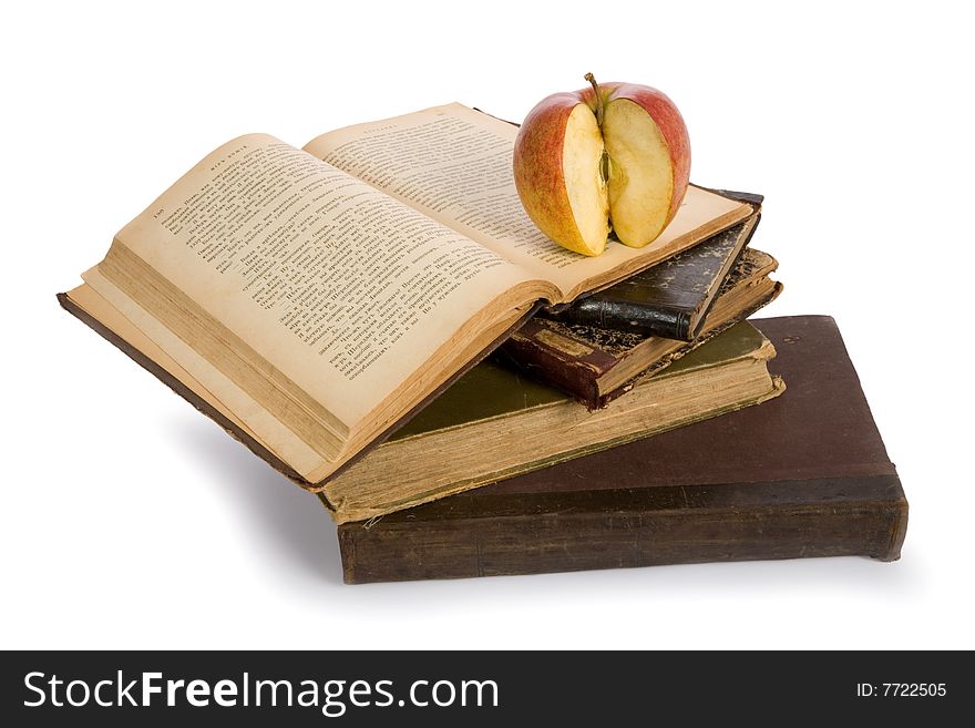 Apple on pile of old books isolated on white