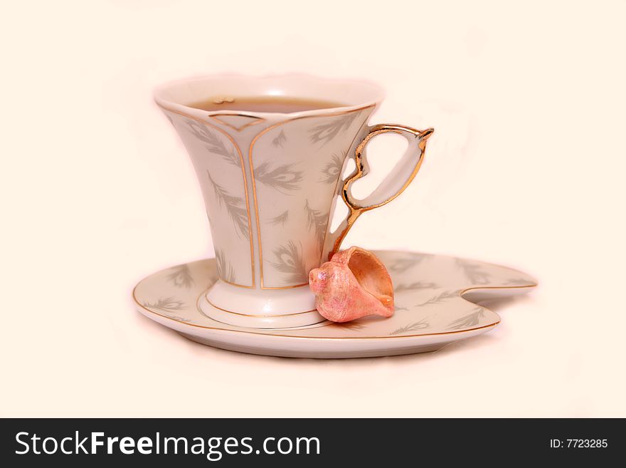 Cup with tea and pink Cockleshell. Cup with tea and pink Cockleshell