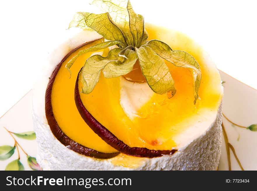 Decoration on a piece of cake from fruits and leaflets. Cake of the whipped cream and fruits isolated on white background. Decoration on a piece of cake from fruits and leaflets. Cake of the whipped cream and fruits isolated on white background.