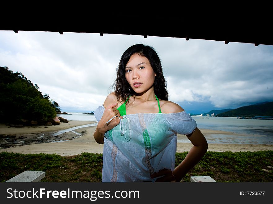 Outdoor asian woman relaxing by the beach. Outdoor asian woman relaxing by the beach