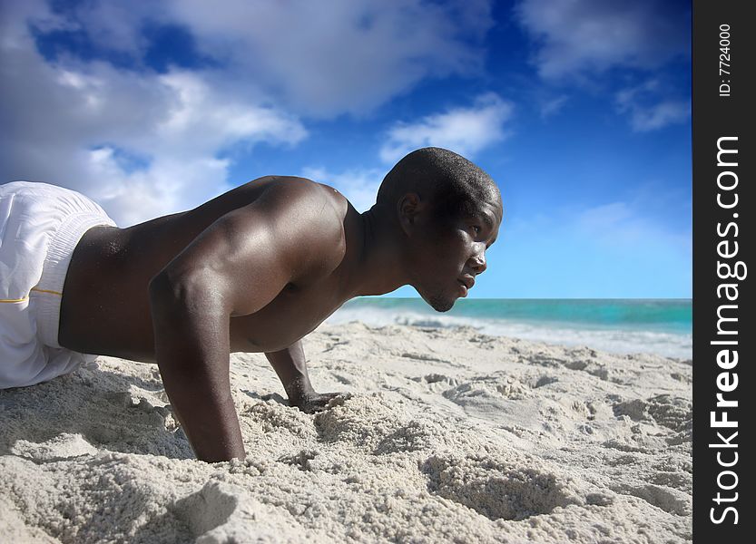 Black man doing flexions on the beach
