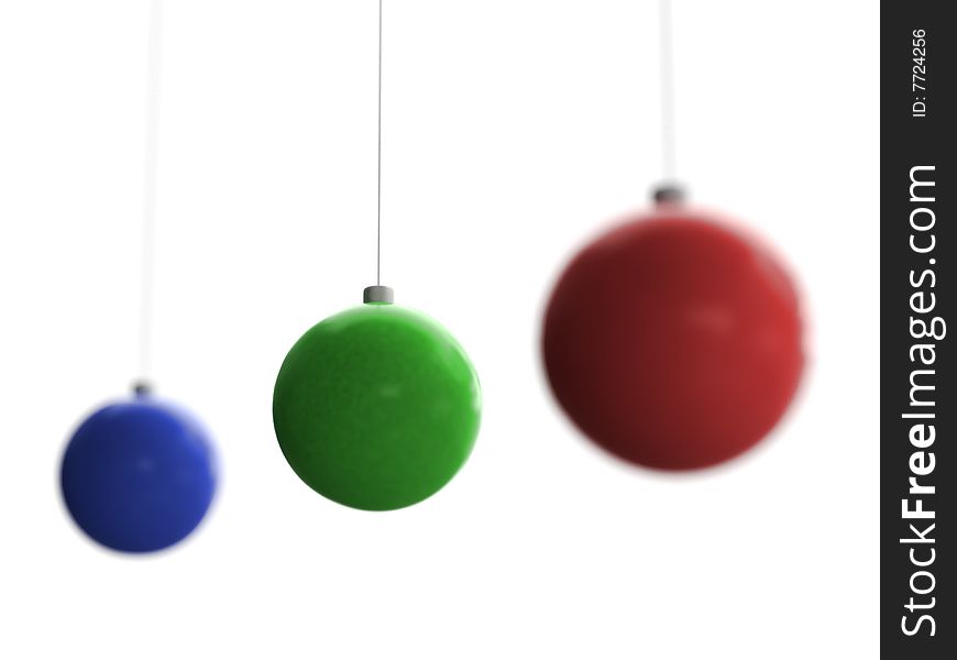 Three Christmas toys of blue, green and red color with middle one in focus hanging on white background