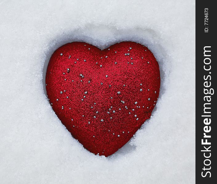 Red toy heart on the snow