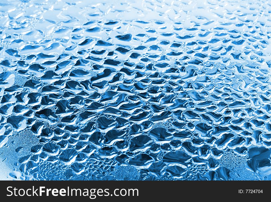 Blue water drops on glass. Pure water background.