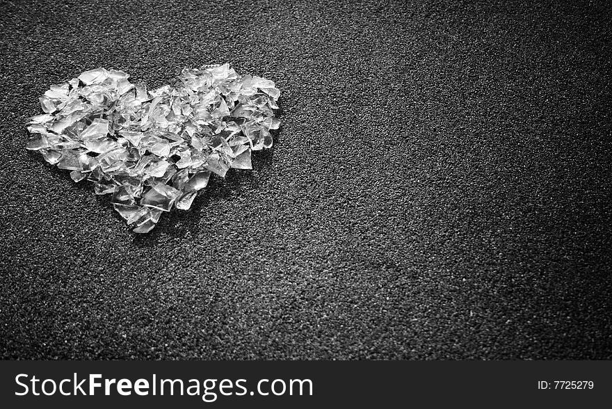 Heart shape made from white glass pieces on gray surface. Heart shape made from white glass pieces on gray surface