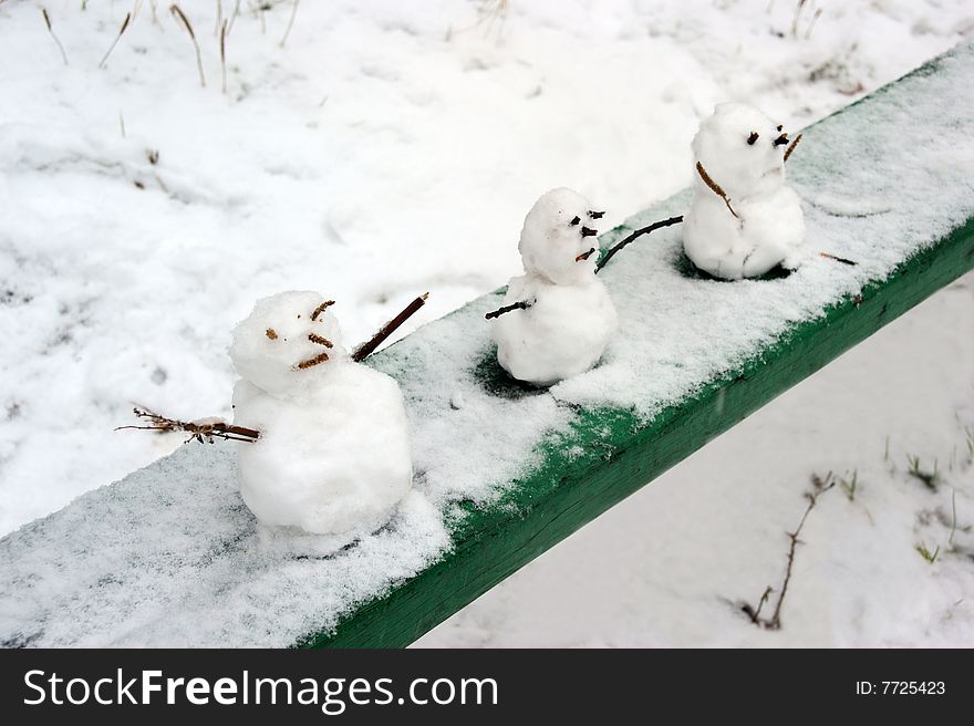 Dolls made from snow cost on bench. Dolls made from snow cost on bench