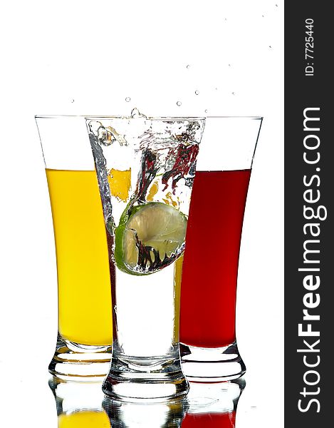 Glasses with juice and lime on the white background
