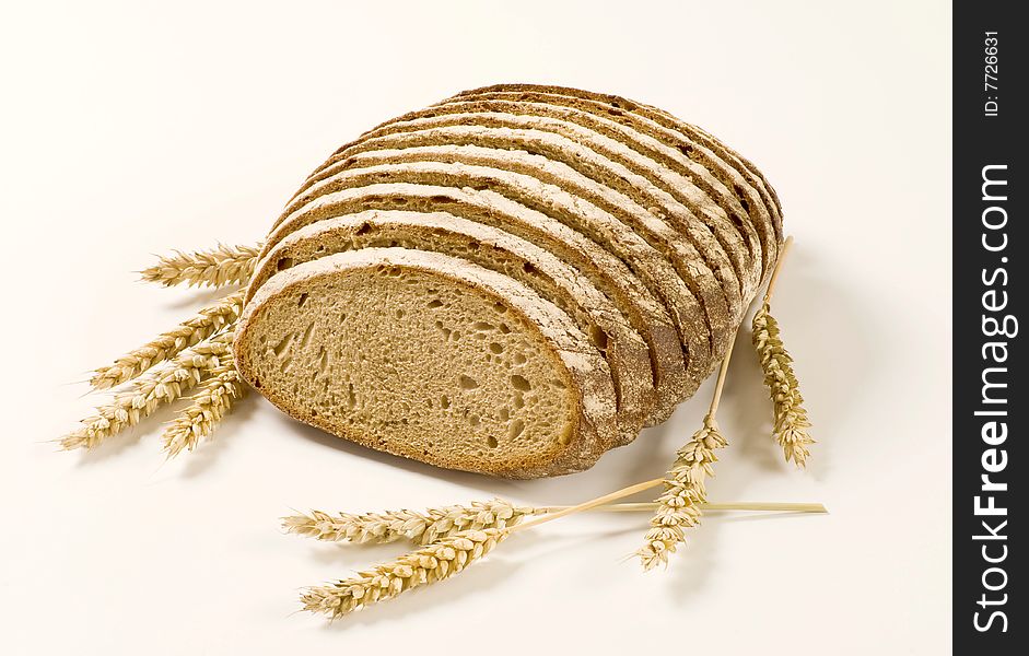 Sliced loaf of bread and wheat ears