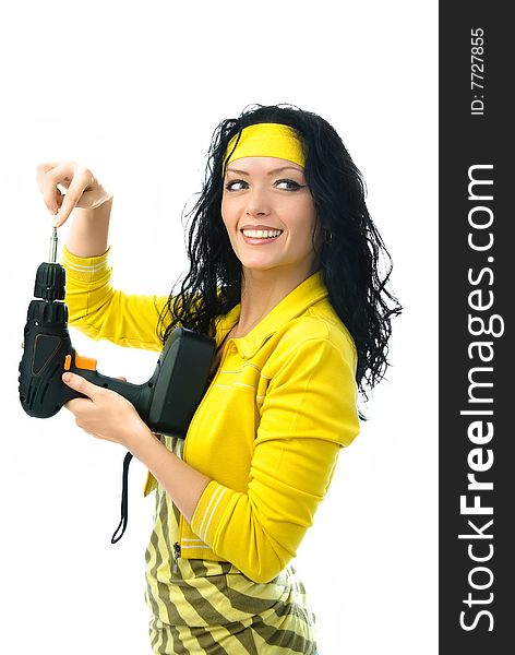 Cheerful young brunette woman holding a drill in her hands isolated against white background. Cheerful young brunette woman holding a drill in her hands isolated against white background