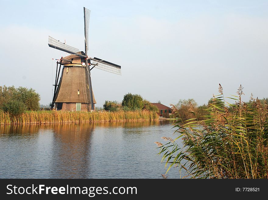 Scenic view of traditional Dutch windmill with canal in foreground, Kinderdijk, Netherlands. Scenic view of traditional Dutch windmill with canal in foreground, Kinderdijk, Netherlands.