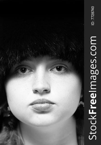 Black-n-white woman portrait in black fur-cap looking to camera