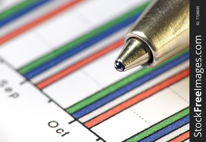 A pen against statistic chart. A pen against statistic chart.