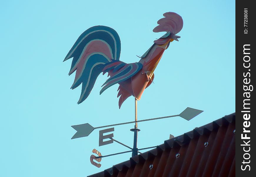Weathervane on roof of metal house to determine wind direction in form. Weathervane on roof of metal house to determine wind direction in form