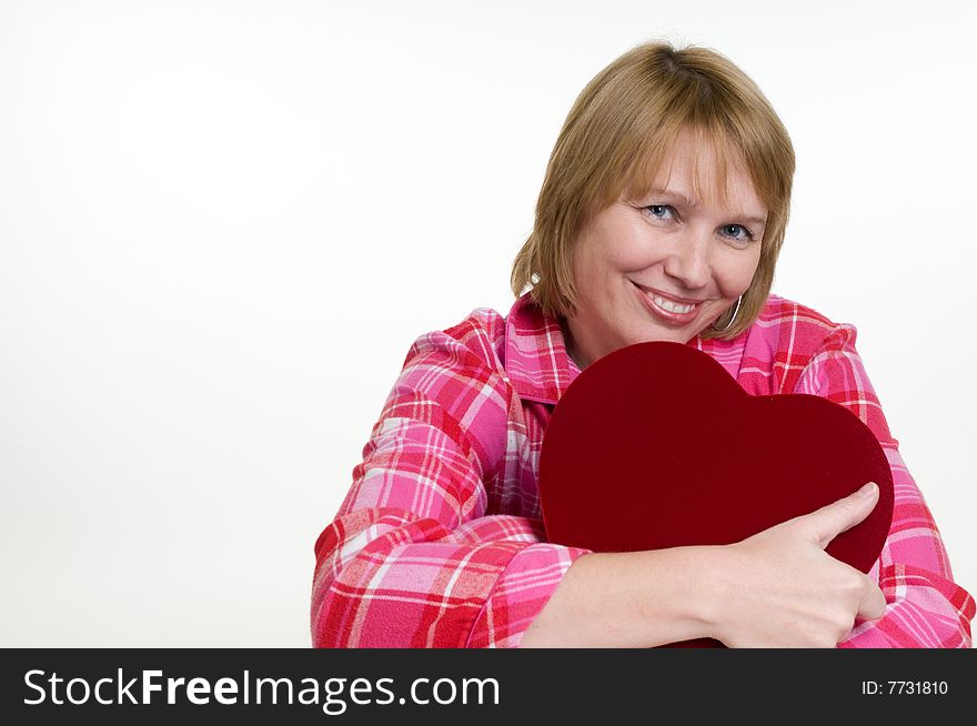 An attractive woman hugs the box of valentines day chocolates she just received as a gift. An attractive woman hugs the box of valentines day chocolates she just received as a gift.