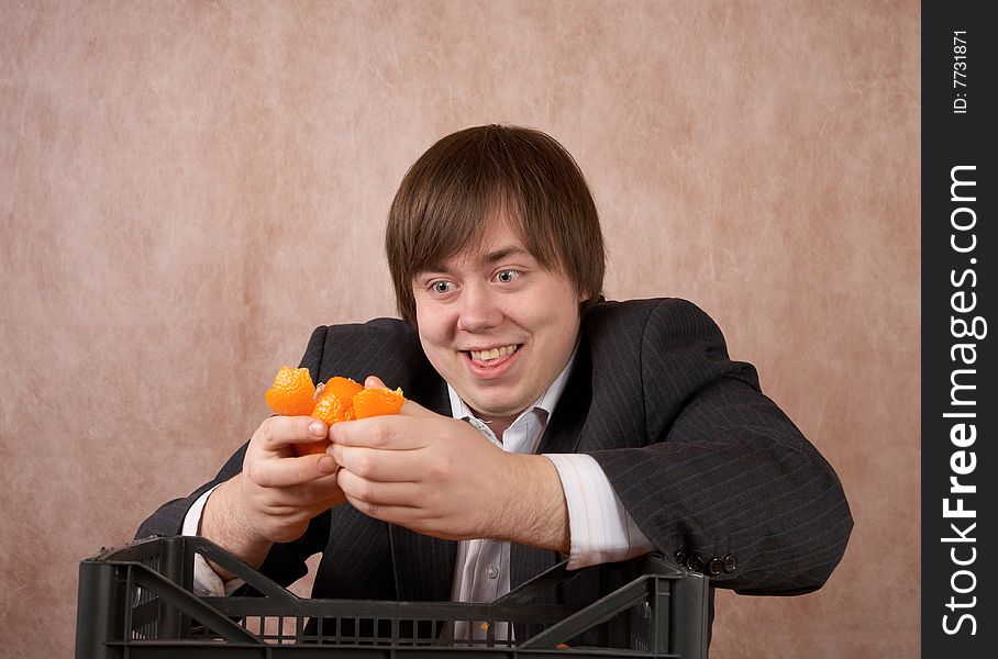 The young man clears a tangerine of a peel