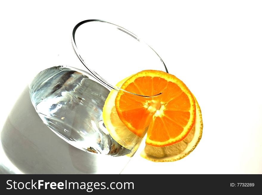 Fresh water with glass, lemon and orange decorated with a circle. Isolated on white background.