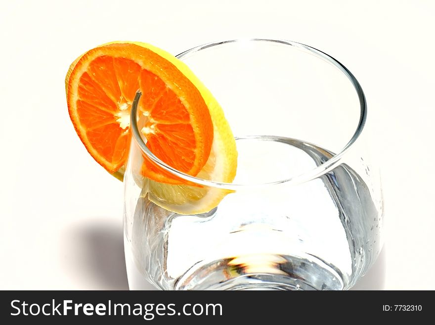 Fresh water with glass, lemon and orange decorated with a circle. Isolated on white background. Fresh water with glass, lemon and orange decorated with a circle. Isolated on white background.