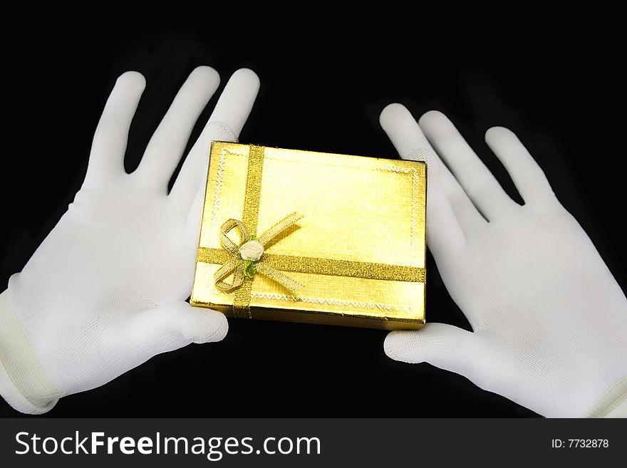 Hands in white gloves with a golden gift
