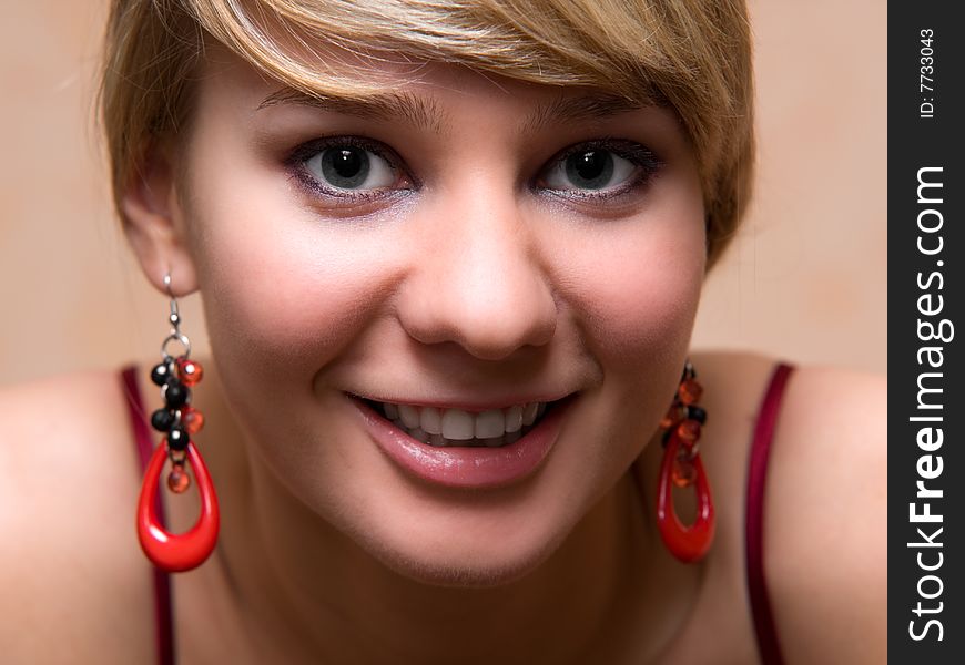 Pretty girl with red pendants - close-up face portrait