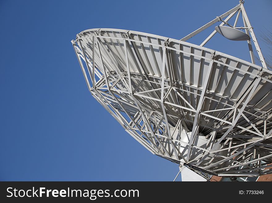 A large satellite dish by parabolic antenna on blue sky