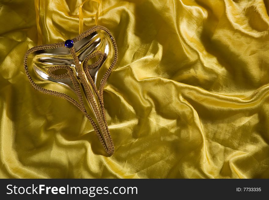 Elegant carnival mask over yellow silk background