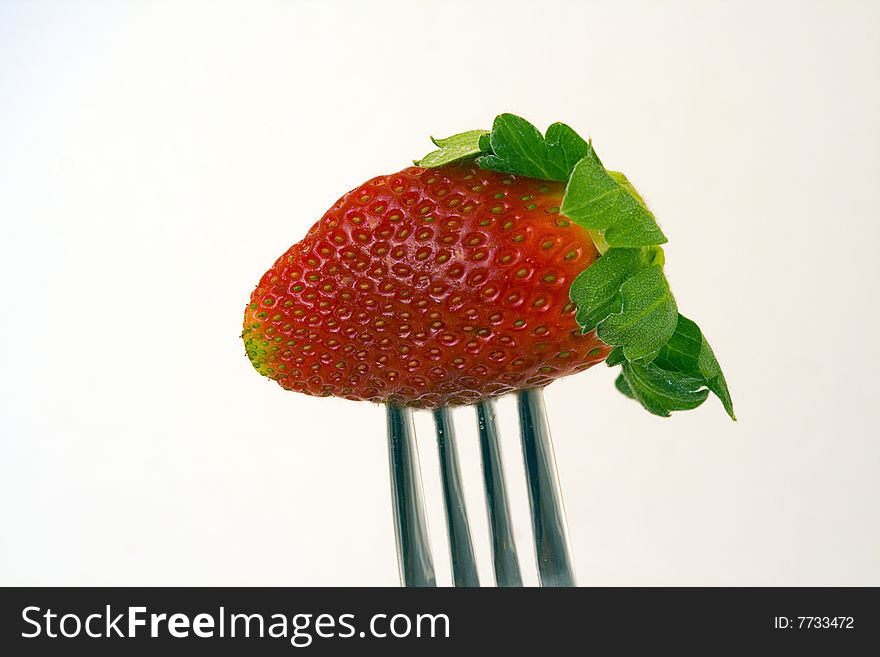 Strawberry on a fork waiting to be eaten