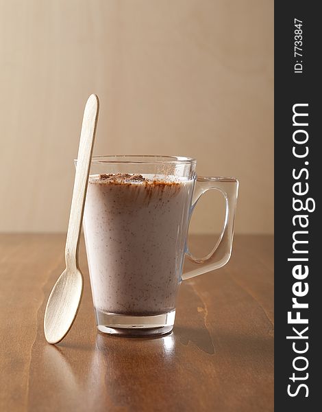 Glass of fresh drinking chocolate with wooden spoon