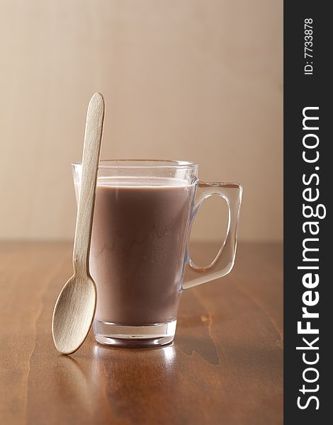 Glass of fresh drinking chocolate with wooden spoon