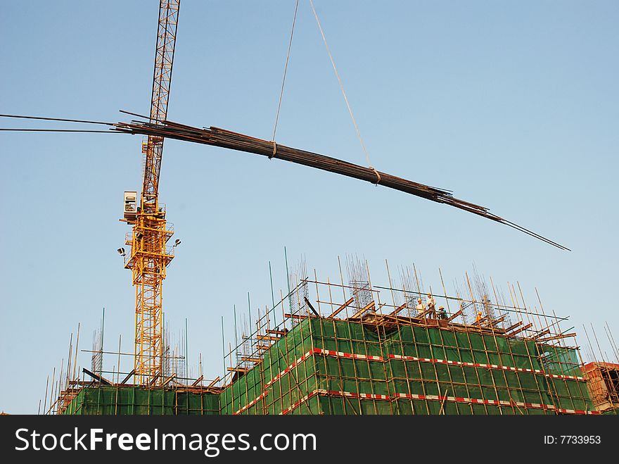 The construction site and high iron crane lifting the steel bars.