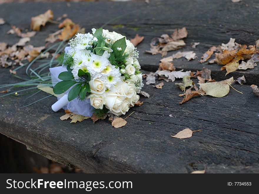 Beautiful wedding bouquet of white flowers lost on bench. Beautiful wedding bouquet of white flowers lost on bench