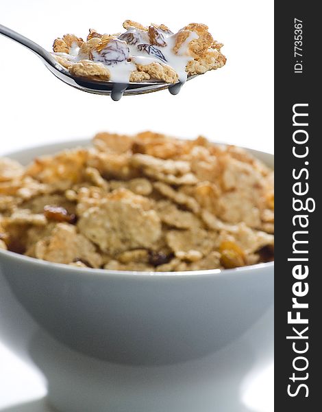 Bowl of cereal with raisins and milk isolated