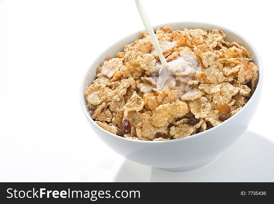 Bowl of cereal with raisins and milk isolated