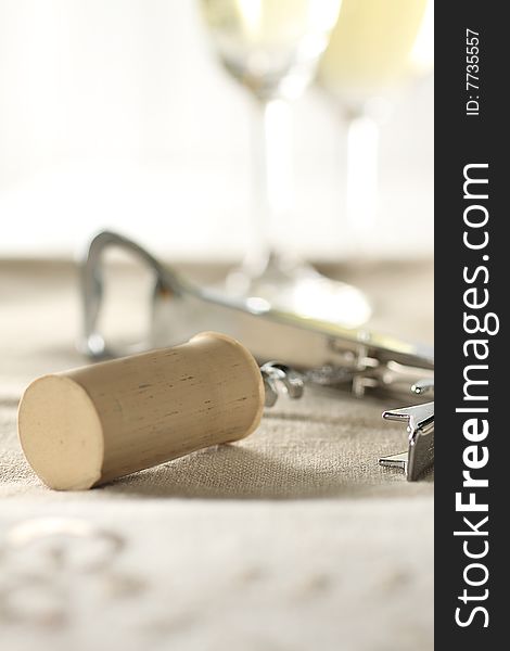 Cork and cork on the linen cloth with two glasses of white wine behind. Cork and cork on the linen cloth with two glasses of white wine behind.